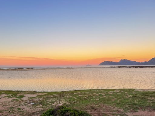 Lagoon / ocean at sunset Kleinrivier Lagoon at sunset with mountain silhouettes and the Atlantic Ocean on the horizon, Hermanus