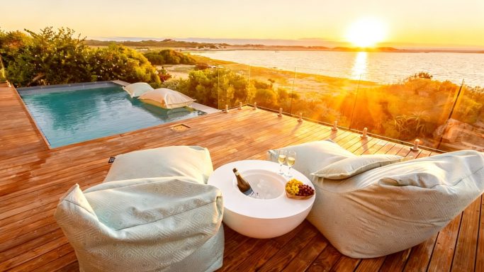 Outdoor lounge area with seating and lagoon view at MBIZI lagoon house