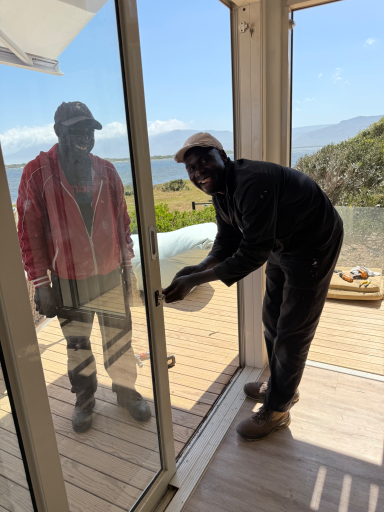 Skilled worker installing large glass windows during the transformation of MBIZI lagoon house