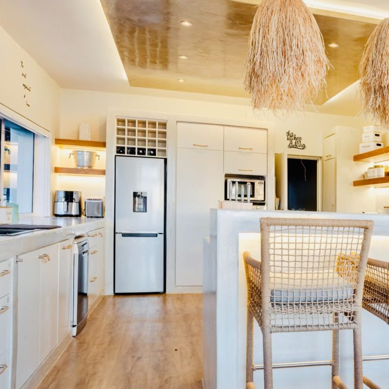 Fully equipped kitchen and dining area at MBIZI lagoon house with natural light and lagoon views