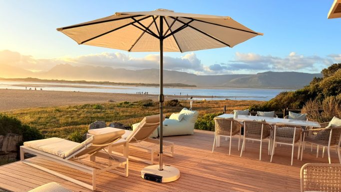 Outdoor lounge area with seating and lagoon view at MBIZI lagoon house
