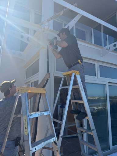 Large sliding glass doors being installed at MBIZI lagoon house to connect interior with the terrace