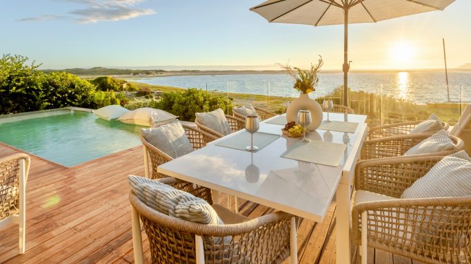 Outdoor lounge area with seating and lagoon view at MBIZI lagoon house